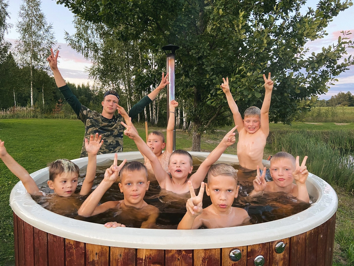 Ребёнок улыбается в окружении друзей на летнем лагере в Латвии